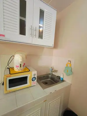 a small kitchen with a microwave and a sink at SimpleRoomDesign, VeryClose Impact Muaungthongthani in Thung Si Kan