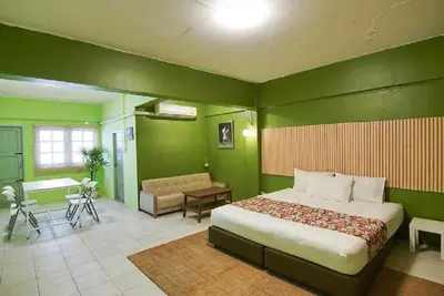 a bedroom with green walls and a bed and a desk at XX GO INN The Grand Palace โกอินน์ พระบรมมหาราชวัง MRT สามยอด in Bangkok