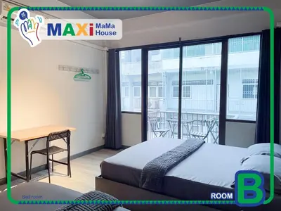 a bedroom with a bed and a desk and a balcony at MAXi MaMa Room in Bangkok