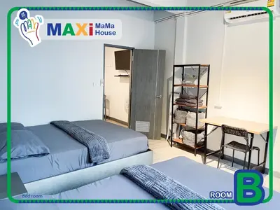 a room with two beds and a table and a desk at MAXi MaMa Room in Bangkok