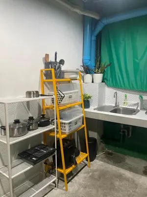 a kitchen with a yellow shelf next to a sink at MAXi MaMa Room in Bangkok