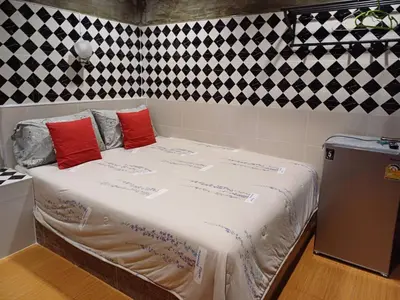 a large bed with red pillows in a room at Gail's Hostels in Bangkok