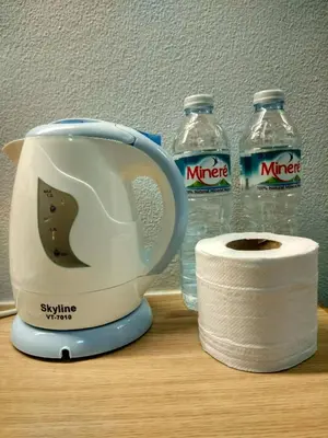 a mixer next to a roll of toilet paper and water bottles at Savi Rooms Premium 1 Near Bkk Piyavet Hospital in Bangkok