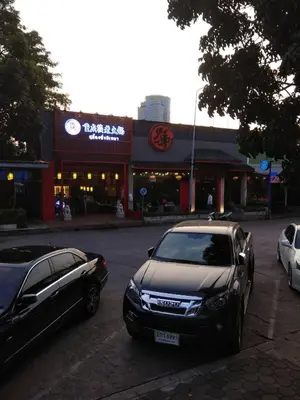 two cars parked in a parking lot in front of a store at Savi Rooms Deluxe 3 Nr Bangkok piyavet Hospital in Bangkok