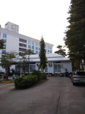 a white building with a car parked in a parking lot at Savi Rooms Deluxe 3 Nr Bangkok piyavet Hospital in Bangkok