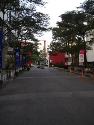 an empty street with trees and a factory in the background at Savi Rooms Super Deluxe Studio 2 Nr Bkk Hospital in Bangkok
