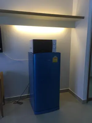 a small blue refrigerator in a room with a light at Savi Rooms Premium studio near bkk Piyavet hospital near most famous pubs in Bangkok