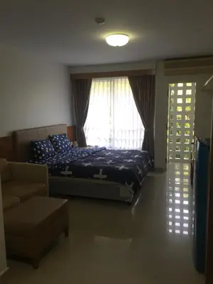 a bedroom with a bed and a couch and a window at Savi Rooms Premium studio near bkk Piyavet hospital near most famous pubs in Bangkok