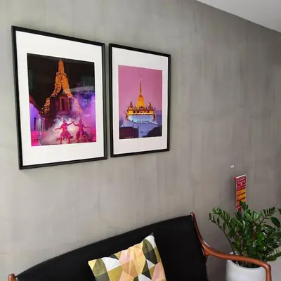 three framed pictures on a wall with a couch at ROOMS at Number60 Khaosan Bangkok in Bangkok