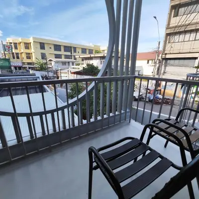 a balcony with two chairs and a balcony with buildings at ROOMS at Number60 Khaosan Bangkok in Bangkok