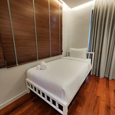 a white bed in a room with wooden floors at ROOMS at Number60 Khaosan Bangkok in Bangkok