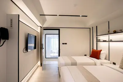 a hotel room with two beds and a tv at Pillow B Hotel in Ban Zong Katiam