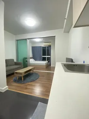 a kitchen and living room with a couch and a table at M Stay in Nonthaburi