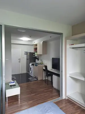 a room with a bed and a desk and a kitchen at M Stay in Nonthaburi