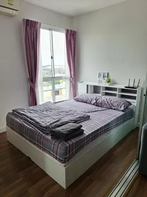 a bedroom with a bed and a window with purple curtains at M Stay in Nonthaburi