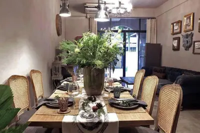a dining room table with a vase of flowers on it at Beautiful 3 Bedroom Baroque House near Asoke BTS in Bangkok