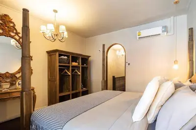 a bedroom with a bed and a chandelier at Beautiful 3 Bedroom Baroque House near Asoke BTS in Bangkok