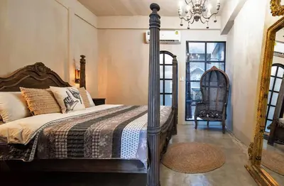 a bedroom with a bed and a mirror and a chair at Beautiful 3 Bedroom Baroque House near Asoke BTS in Bangkok