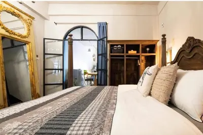 a bedroom with a large bed and a mirror at Beautiful 3 Bedroom Baroque House near Asoke BTS in Bangkok