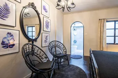 a room with chairs and a mirror on the wall at Beautiful 3 Bedroom Baroque House near Asoke BTS in Bangkok
