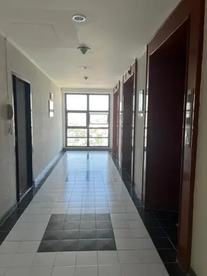an empty hallway in a building with a window at Regent Srinakarin18 in Amphoe Phra Khanong