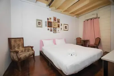 a bedroom with a large white bed and a chair at XX Mitr Inn Yaowarat 2 - มิตร อินน์ เยาวราช in Bangkok
