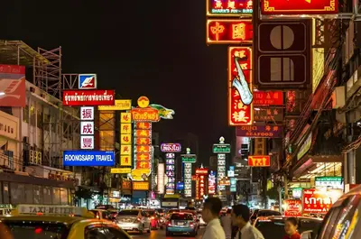 a busy city street at night with neon signs at XX Mitr Inn Yaowarat 2 - มิตร อินน์ เยาวราช in Bangkok