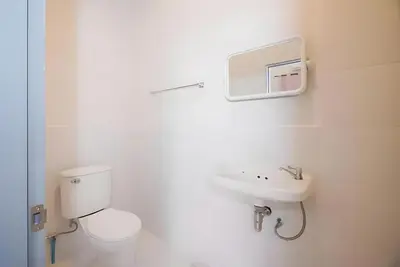a white bathroom with a toilet and a sink at XX Mitr Inn Yaowarat 2 - มิตร อินน์ เยาวราช in Bangkok
