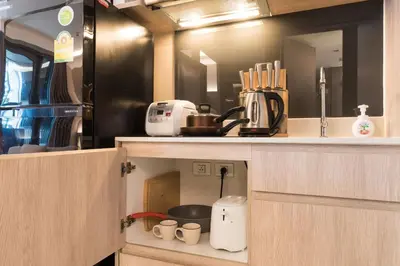 a kitchen with a coffee maker and cups in a cabinet at bts thong lor \u6e38\u6cf3\u6c60-\u514d\u8d39\u65e0\u7ebf\u7f51\u7edc in Bang Khen