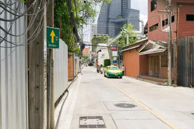 a street with a green car parked on the side of a building at bts thong lor \u6e38\u6cf3\u6c60-\u514d\u8d39\u65e0\u7ebf\u7f51\u7edc in Bang Khen