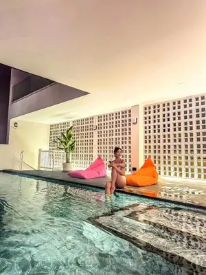 a woman sitting on pillows next to a swimming pool at \u66fc\u8c37\u6cf0\u5883\u5962\u5922\u5225\u5885 in Ban Nong Rong (1)