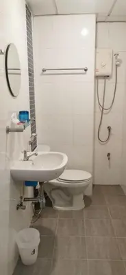 a white bathroom with a toilet and a sink at Victory Room in Bangkok