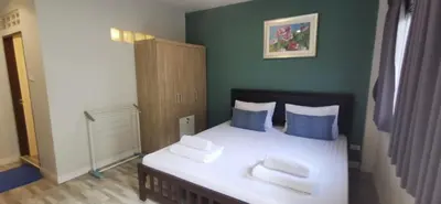 a bedroom with a white bed with blue pillows at Victory Room in Bangkok