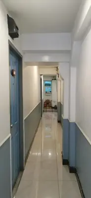 a hallway of a hospital with a blue door at Victory Room in Bangkok