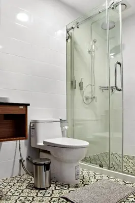 a bathroom with a toilet and a glass shower at The Residences at C&C in Bangkok