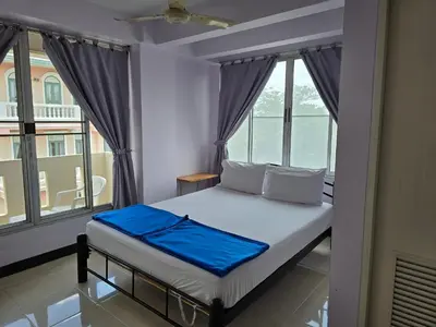 a bedroom with a bed with a large window at Bella Bella Riverview in Bangkok