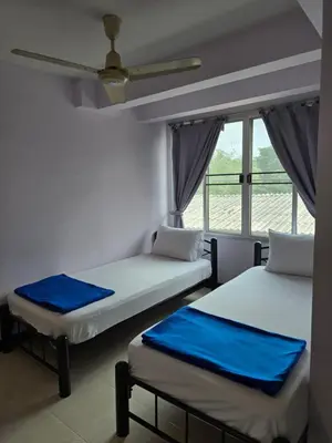 two beds in a room with a window at Bella Bella Riverview in Bangkok