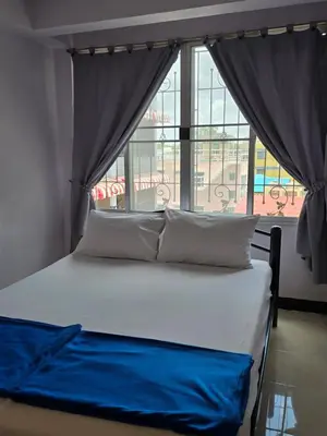 a bed in a room with a large window at Bella Bella Riverview in Bangkok
