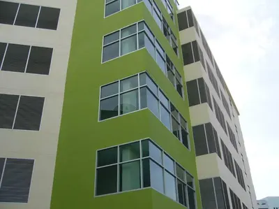 a tall green and white building with many windows at 181 Ekkamai Studio Apartment in Bangkok
