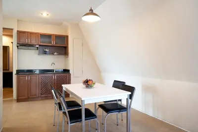 a kitchen and dining room with a white table and chairs at 181 Ekkamai Studio Apartment in Bangkok