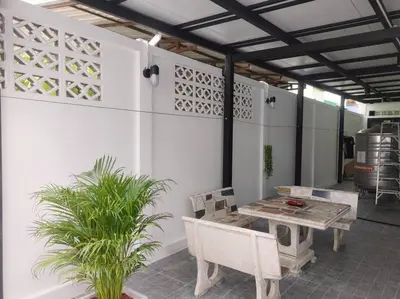 a patio with a table and chairs and plants at \u8f89\u714c\u591c\u5e02 4\u623f\u6cf3\u6c60\u82b1\u56ed\u522b\u5885 \u8ba24\u65e5\u63d0\u4f9b\u514d\u8d39\u63a5\u673a\u4e00\u6b21 in Bangkok