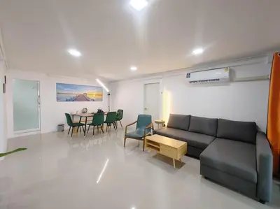 a living room with a couch and a table and chairs at \u8f89\u714c\u591c\u5e02 4\u623f\u6cf3\u6c60\u82b1\u56ed\u522b\u5885 \u8ba24\u65e5\u63d0\u4f9b\u514d\u8d39\u63a5\u673a\u4e00\u6b21 in Bangkok