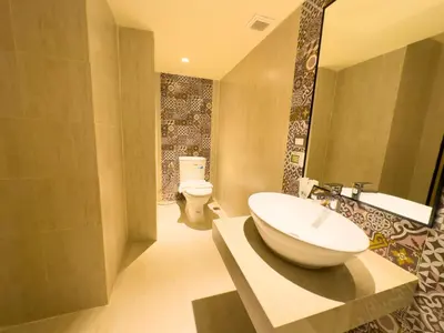 a bathroom with a sink and a toilet at Kastel Bangkok Hotel in Bangkok