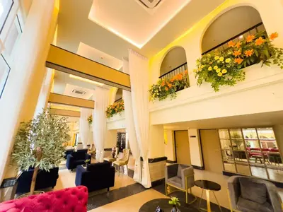 a lobby with couches and chairs and flowers at Kastel Bangkok Hotel in Bangkok