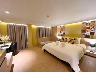 a hotel room with a bed and a desk at Kastel Bangkok Hotel in Bangkok