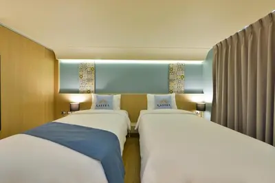two beds sitting next to each other in a room at Kastel Bangkok Hotel in Bangkok