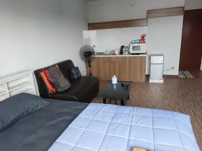 a room with a bed and a couch and a microwave at Solitude Skies14th Floor Studio in Nonthaburi
