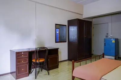 a room with a desk and a chair and a table at Petch Tower Ekkamai in Bangkok
