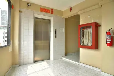 a elevator in a building with a red door at Petch Tower Ekkamai in Bangkok