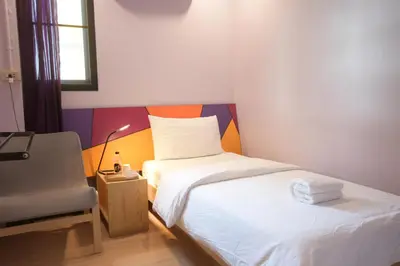 a small room with a bed and a chair at Room@Vipa in Bangkok